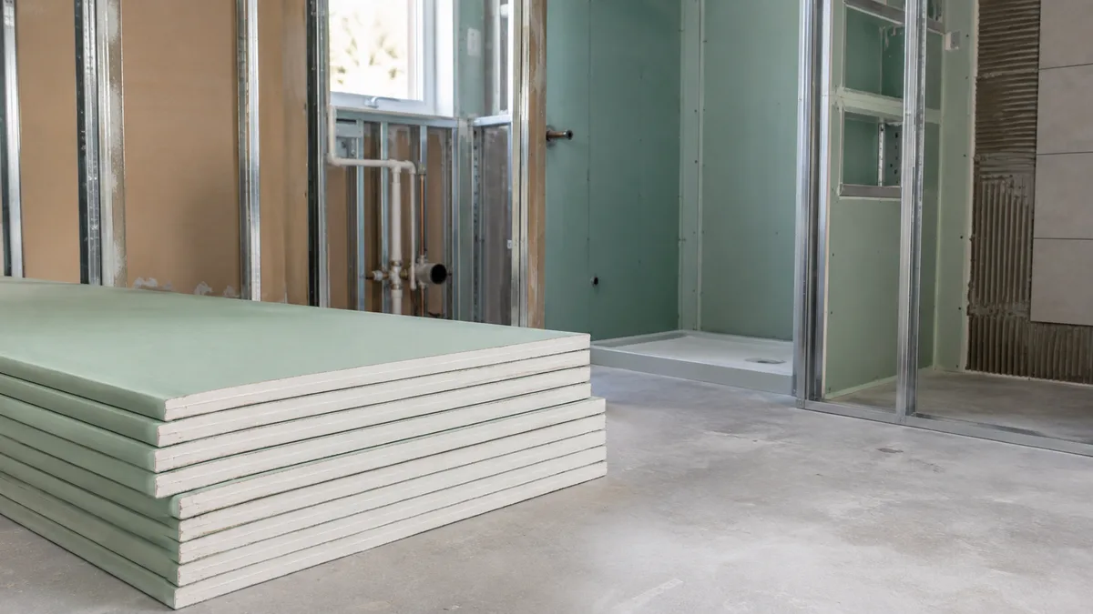 Unbranded green moisture-resistant plasterboards in a wet-area installation